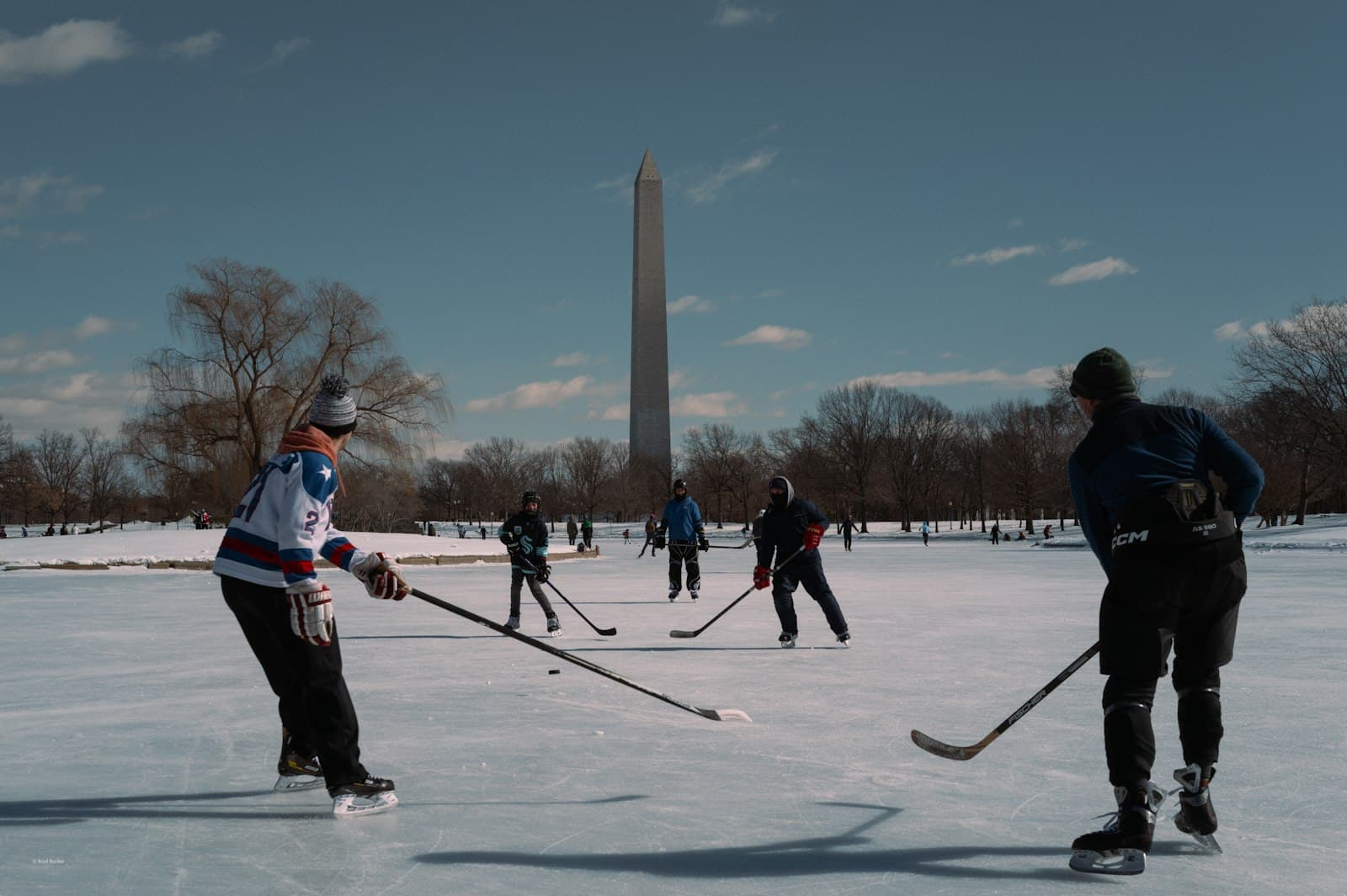 A pick-up game on a frozen pond in a city park