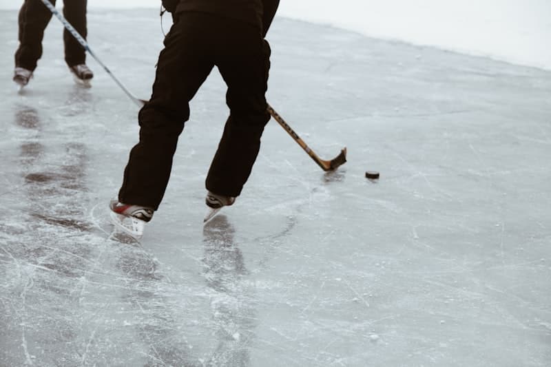 Skates, sticks, and a puck on natural ice